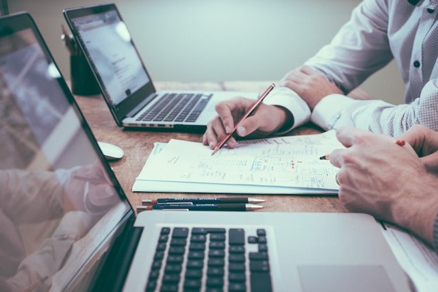 Financial planning documents and laptops during a strategy session